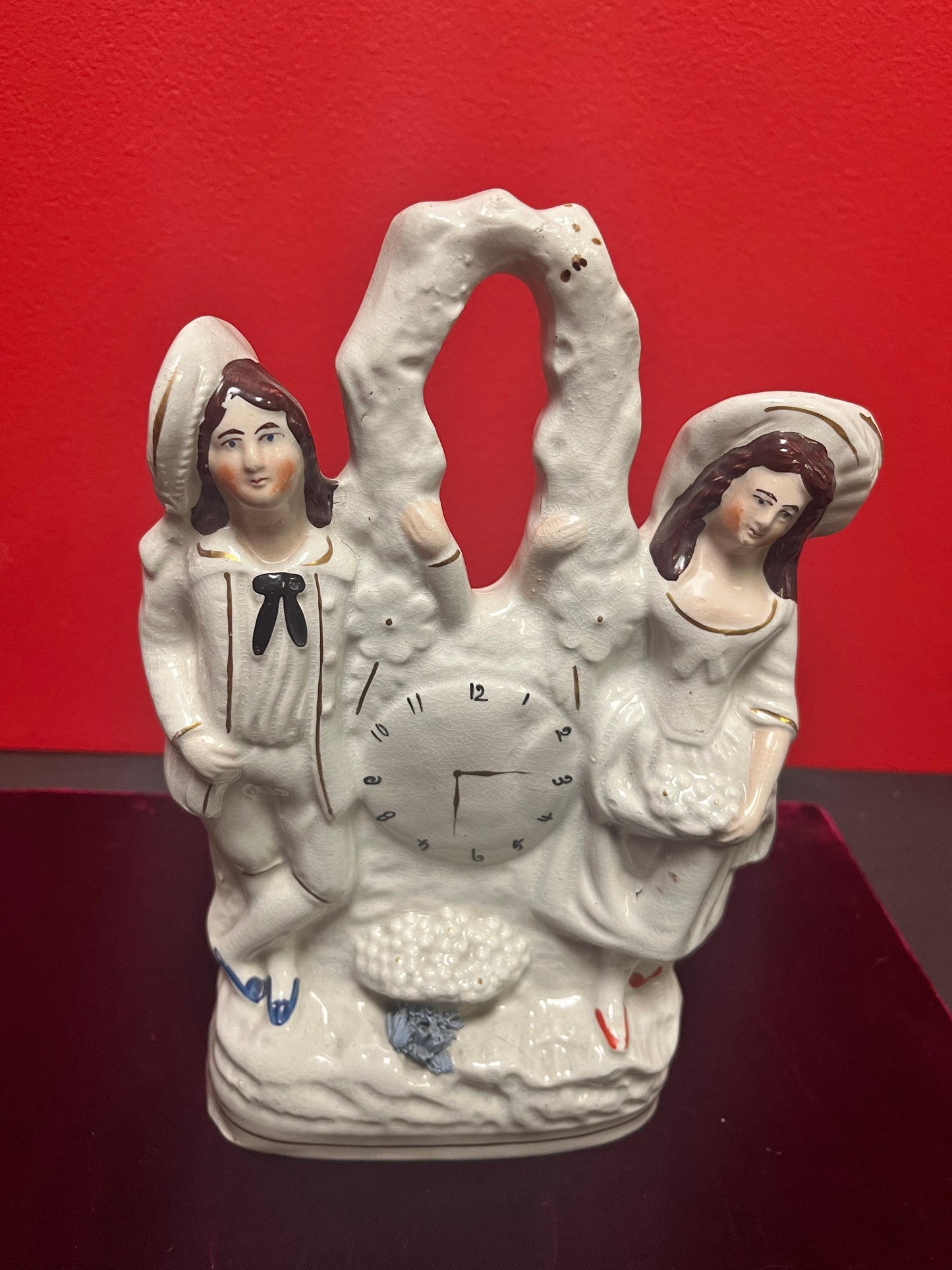 10 inch tall antique Staffordshire couple, holding a clock statue - great antique condition see photos