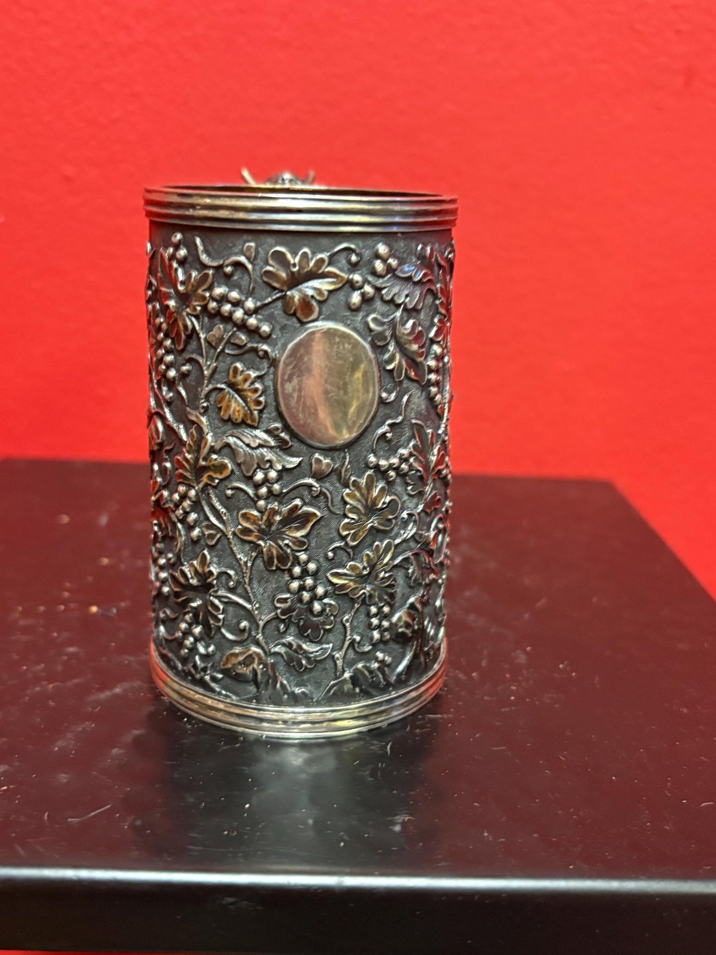 A Chinese export silver mug with flowers and foliage engraved within decorative panels; and a dragon handle. Marked with LC, for Leeching, 利