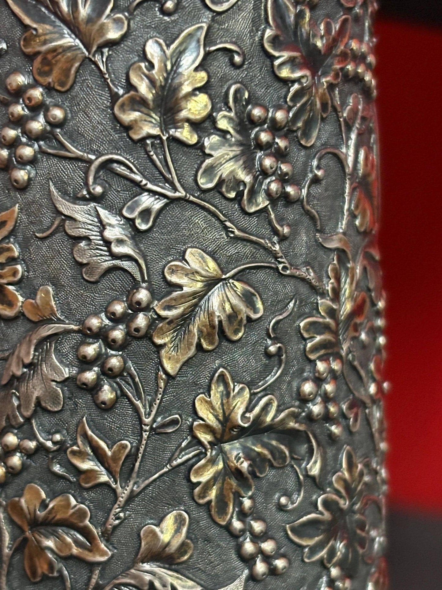 A Chinese export silver mug with flowers and foliage engraved within decorative panels; and a dragon handle. Marked with LC, for Leeching, 利