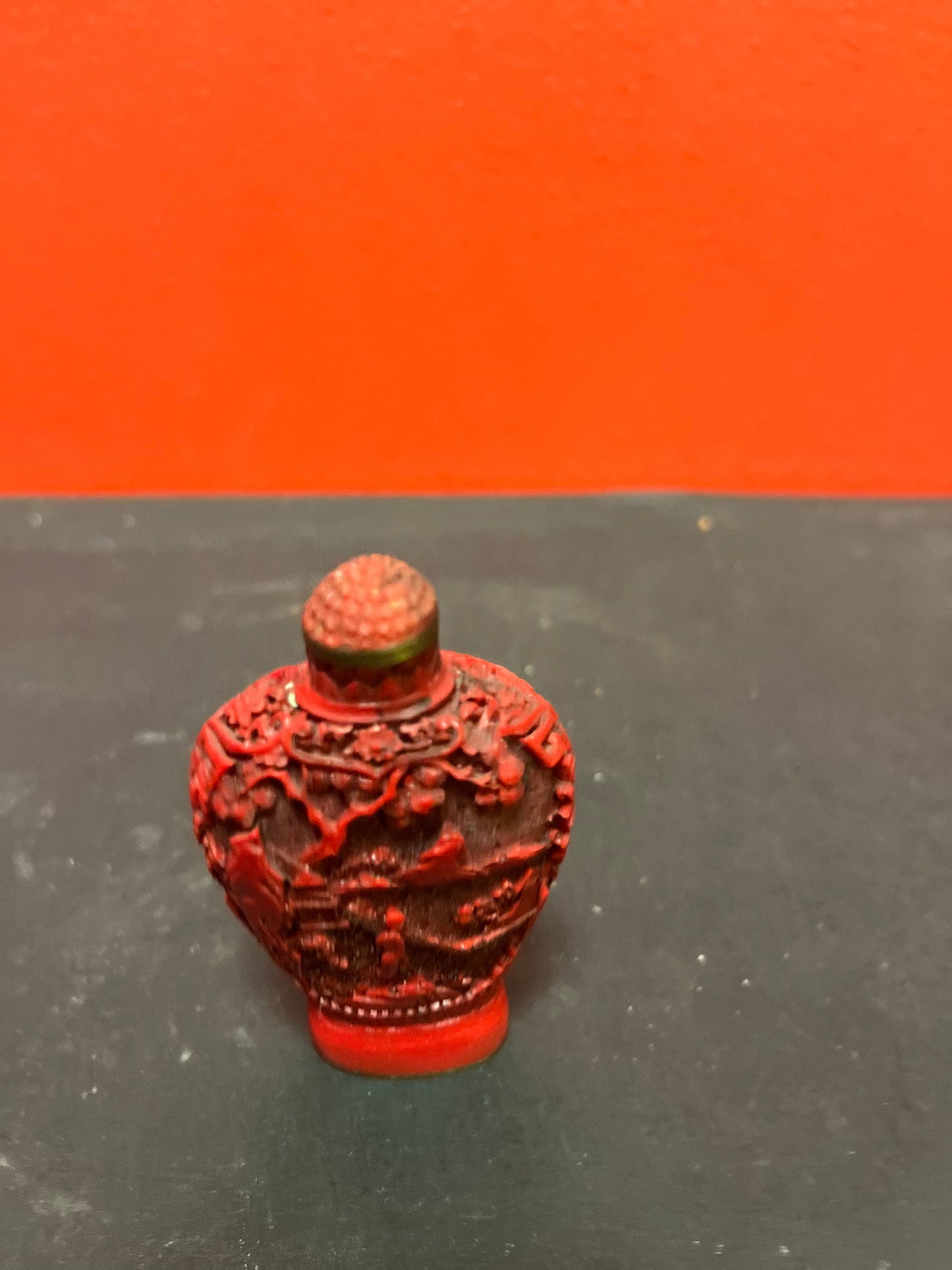 A  Chinese 3 inch high well detailed cinnabar  snuff bottle  great condition, but top is stuck.  low price