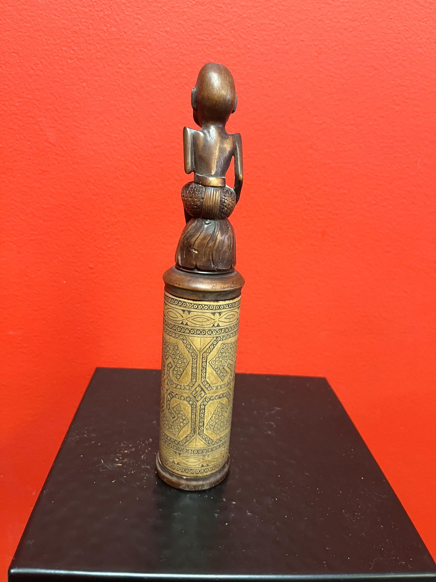 An 8 inch tall  African wooden canister with beautiful carved man on top  highly detailed and wonderful imagery  great value