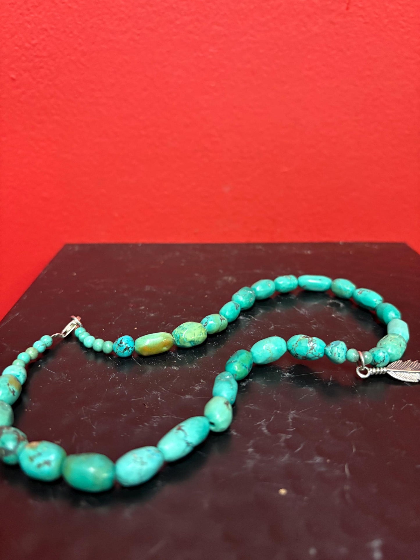 Beautiful approximately 14 inch long turquoise necklace with silver feather charm