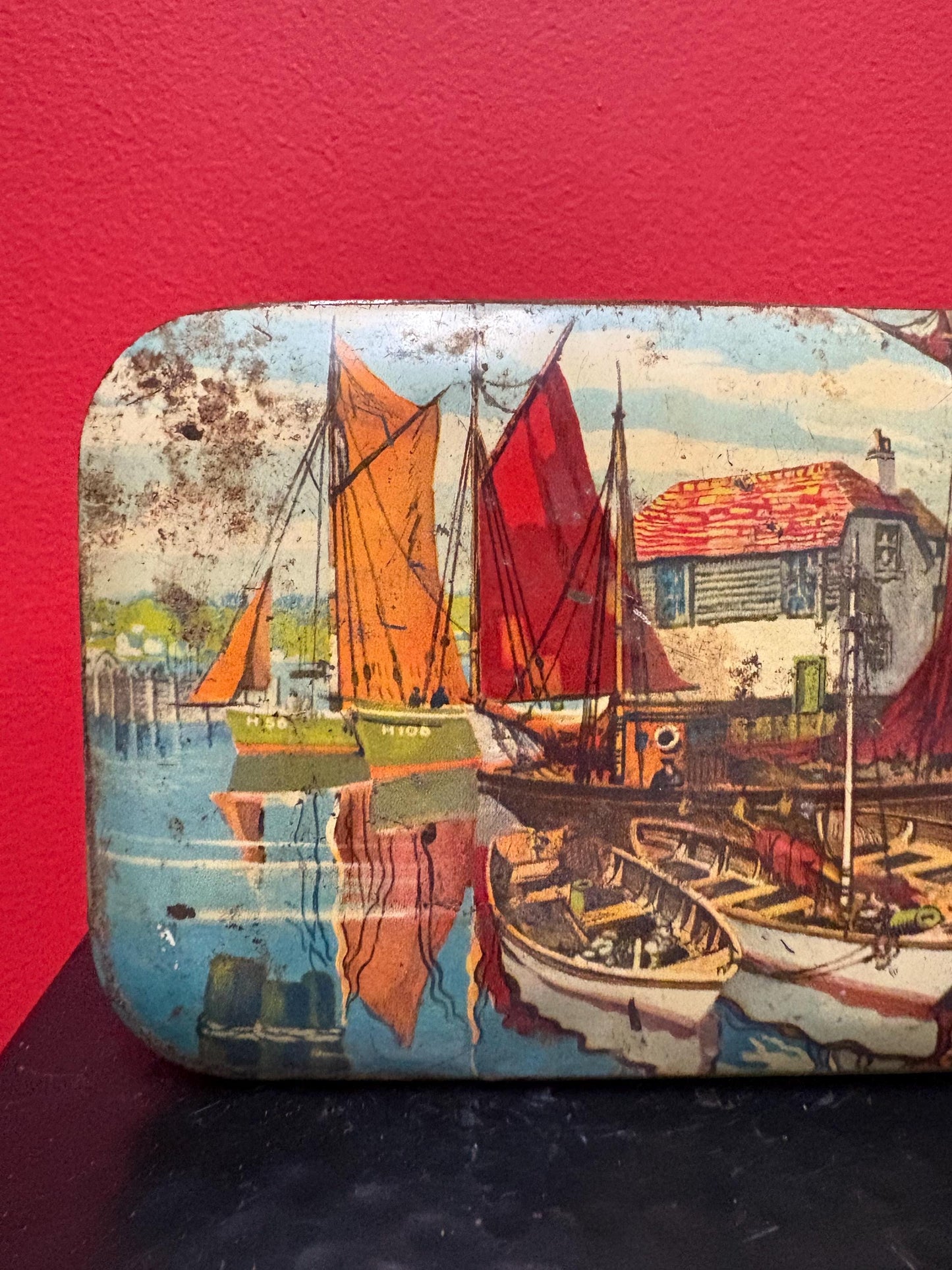 Lovely 5 1/2 x 4 x 1.25 high antique toffee tin with boats scene  old used condition